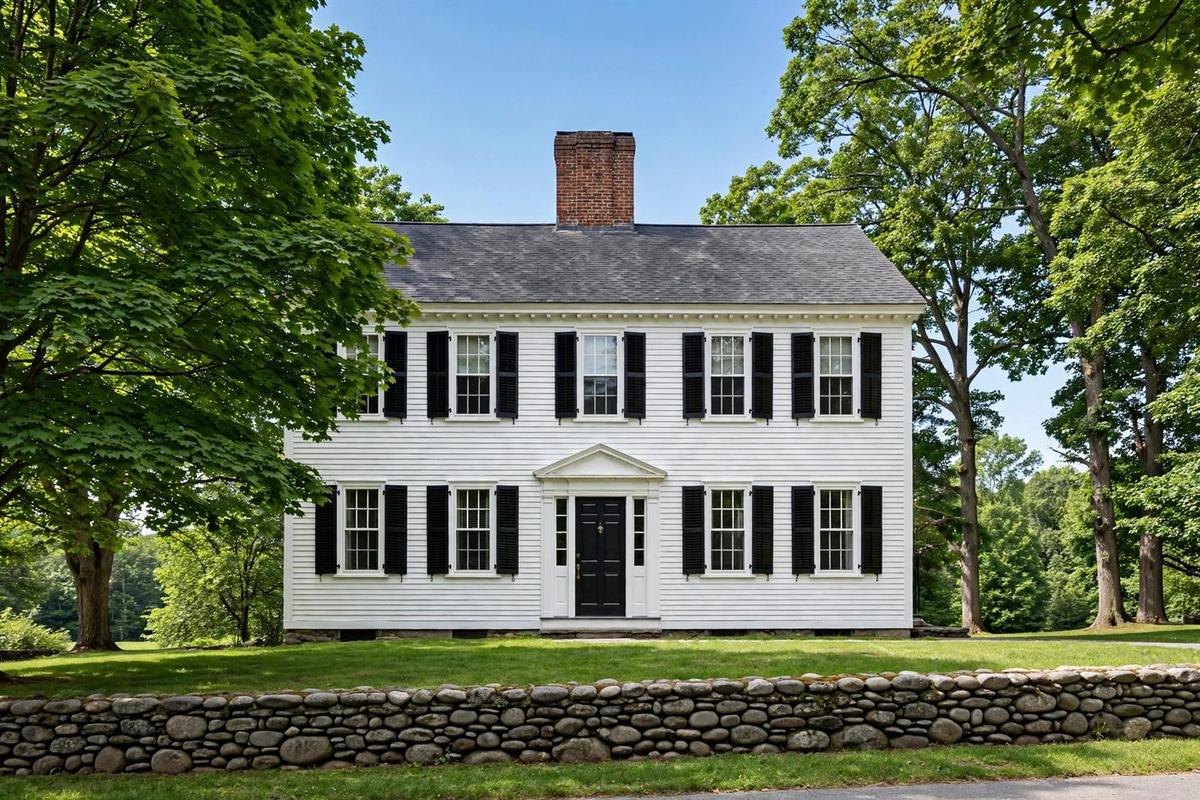 Upscale red-brick Georgian Colonial home in Lexington, Massachusetts with white trim, front columns and manicured lawn.