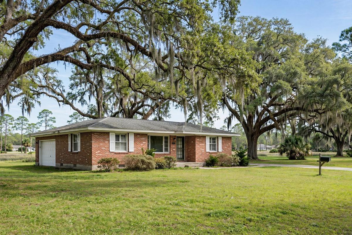 A Lowcountry home on Johns Island with a deep wraparound porch, raised foundation and moss-draped live oak.