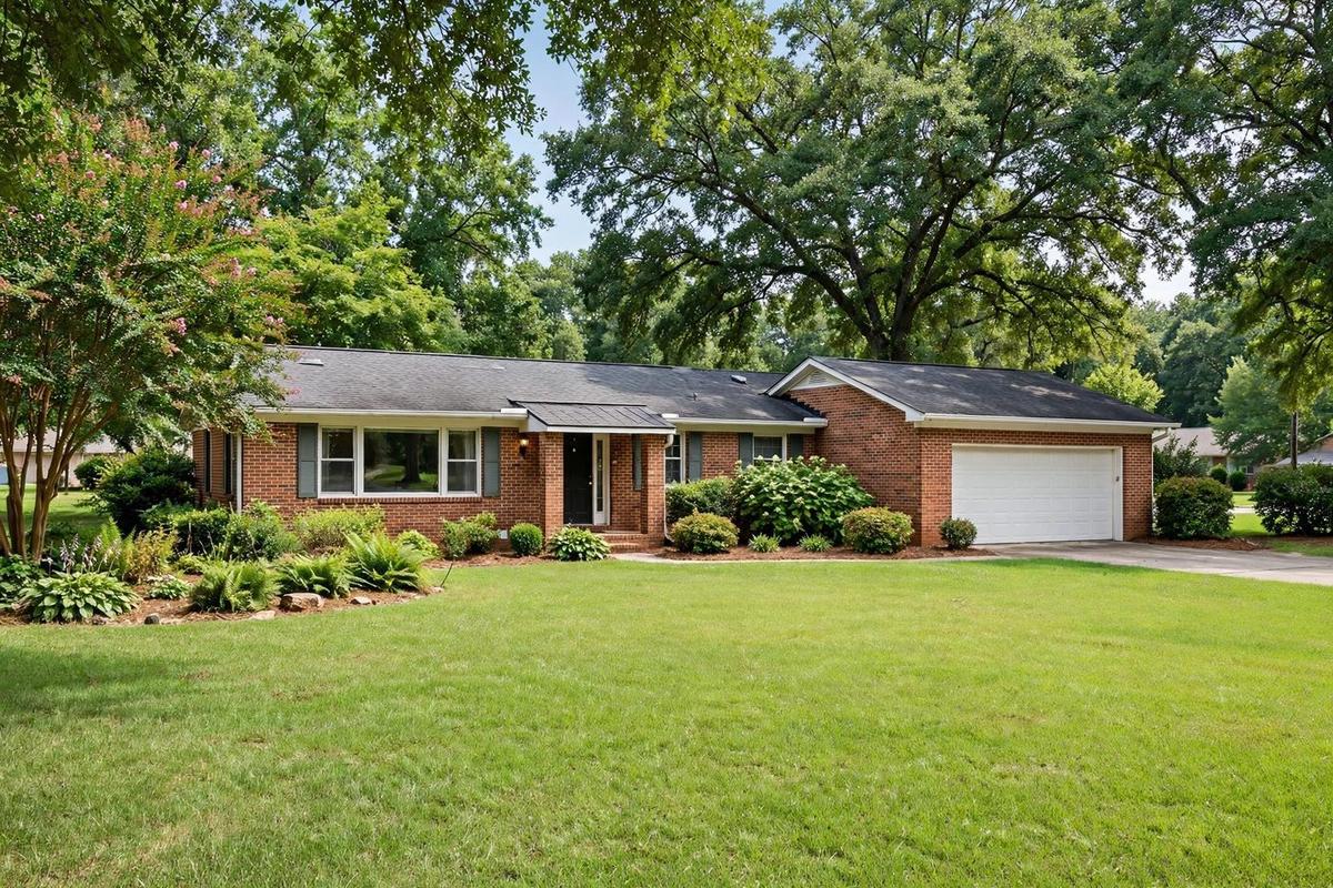 A traditional home in Roswell with brick and cedar shake facade, gabled roof and covered porch with stone columns.